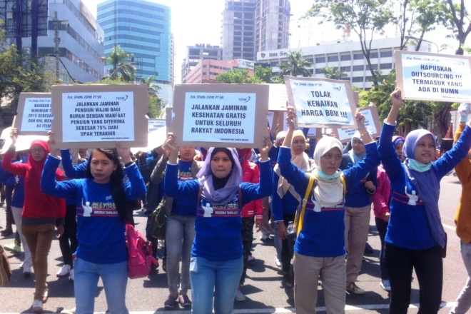 Massa aksi dari FSPMI-KSPI Jawa Timur mengangkat spanduk berisi tuntutan dalam aksi di Gedung Negara Grahadi, Surabaya. Tanggal 2 Oktober 2014. | Foto: Kascey